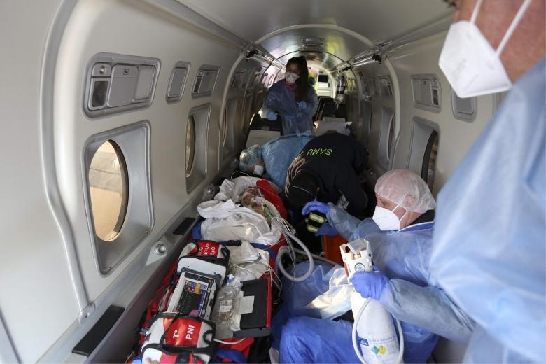 Nhân viên y tế chăm sóc bệnh nhân COVID-19 trên một chuyến bay cấp cứu ở Pháp. Ảnh: AFP