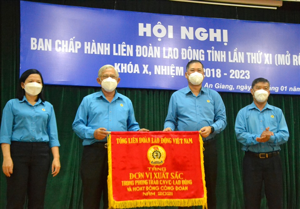 Ông Nguyễn Minh Dũng (thứ 2 từ phải sang) trao Cờ thi đua xuất sắc năm 2021 của Tổng LĐLĐ Việt Nam cho LĐLĐ tỉnh An Giang. Ảnh: LT