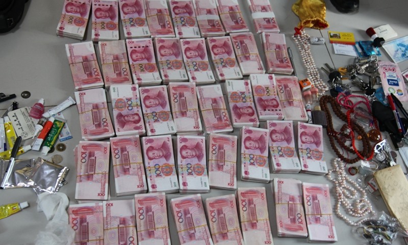 Cảnh sát phát hiện nhiều tiền mặt và ngoại tệ tại nơi ở của Wang. Ảnh: Hoàn cầu Thời báo.