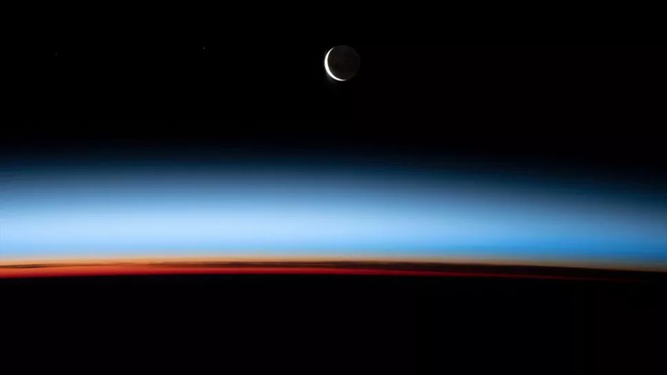 Một phi hành gia Trạm Vũ trụ Quốc tế đã chụp được bức ảnh tuyệt đẹp về mặt trăng lưỡi liềm khi ánh sáng cuối cùng của mặt trời lặn chiếu qua các lớp khác nhau của khí quyển Trái đất.