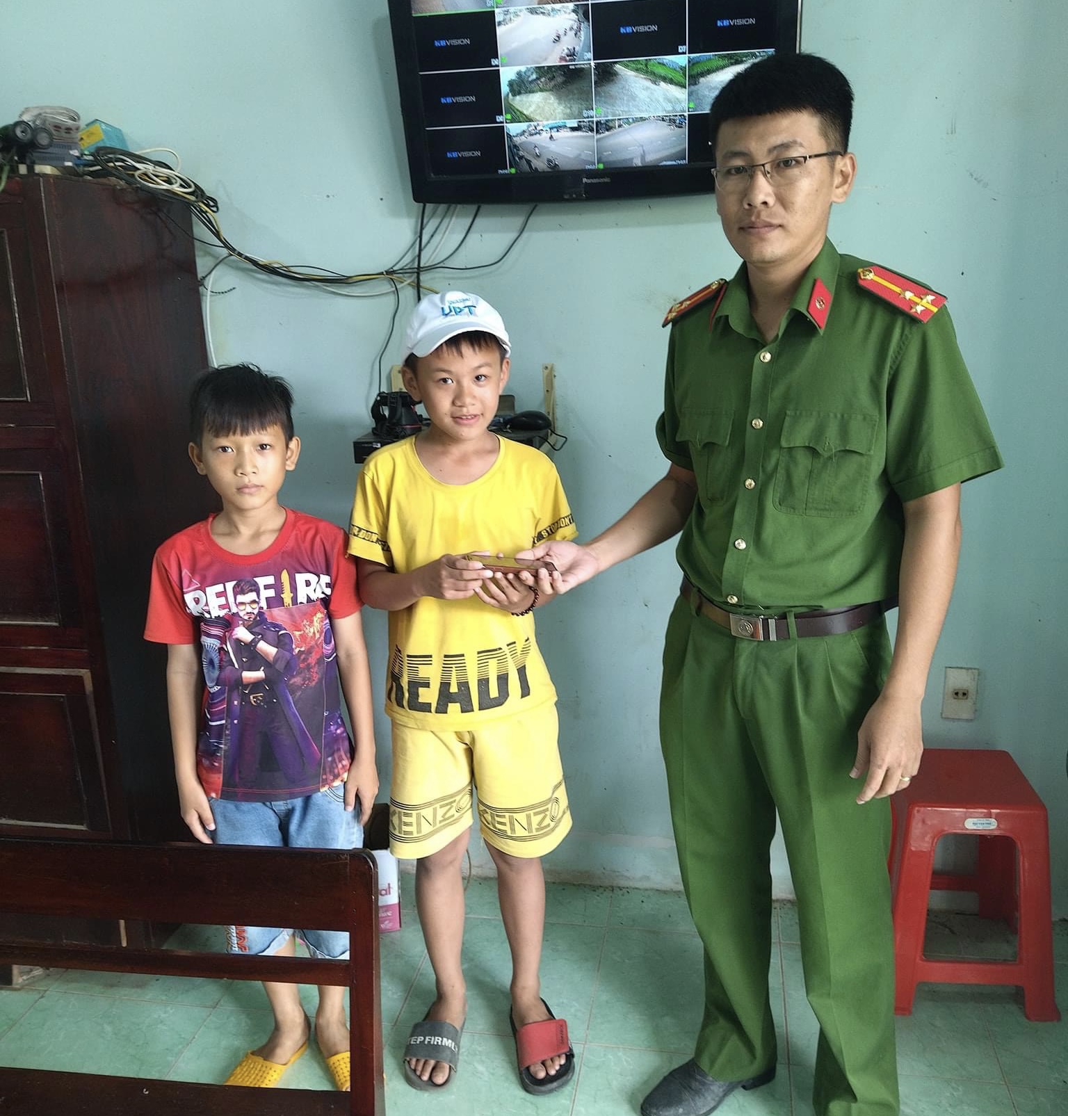 2 em học sinh mang điện thoại nhặt được đến công an xã Hàm Trí. Ảnh: CA