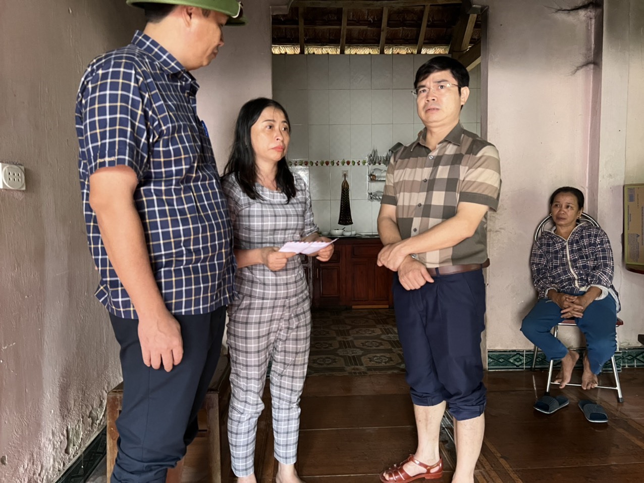 Chủ tịch - Phó Chủ tịch UBND huyện Thanh Chương trao hỗ trợ, động viên cô giá Phan Thị Trà. Ảnh: QĐ