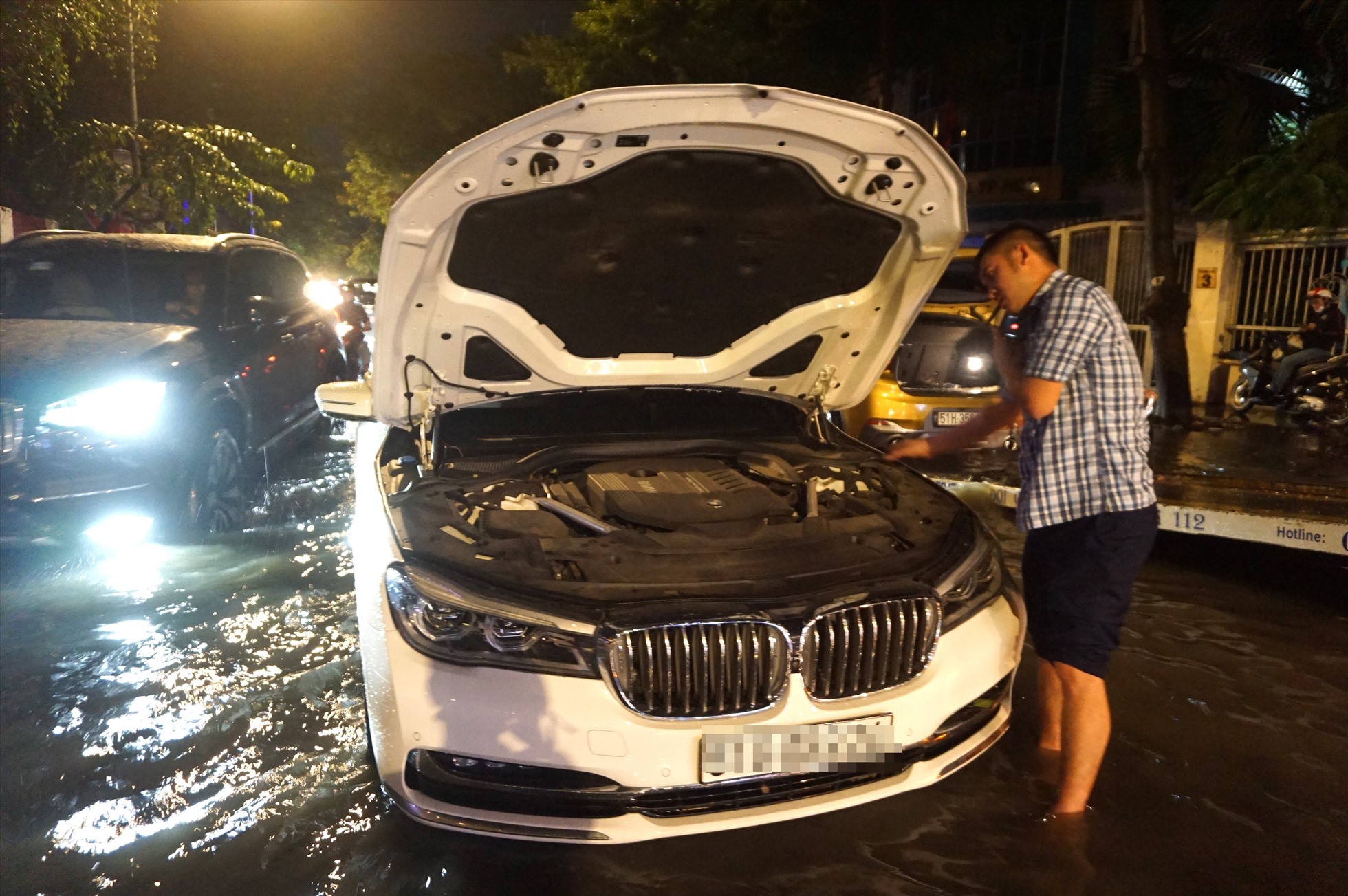 Một chiếc BMW khắc bị chết máy giữa dòng nước khiến tài xế phải gọi cứu hộ.