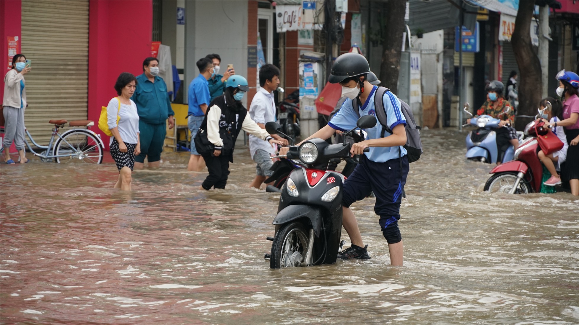 Quan sát tại đường Trần Hưng Đạo, mực nước dâng cao hơn nửa bánh xe máy.