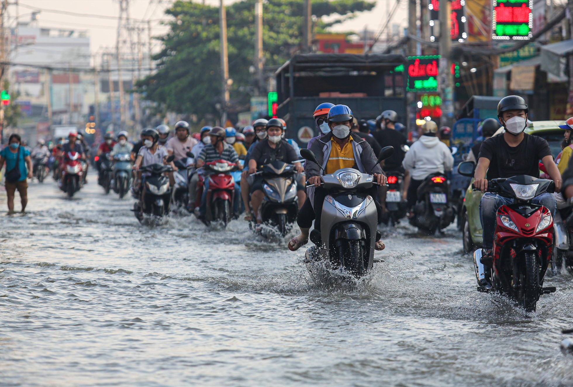 Tương tự, tại Quốc lộ 50 (đoạn qua xã Phong Phú, huyện Bình Chánh), nước cũng dâng cao từ 10-30cm, việc đi lại của người dân gặp khá nhiều khó khăn.