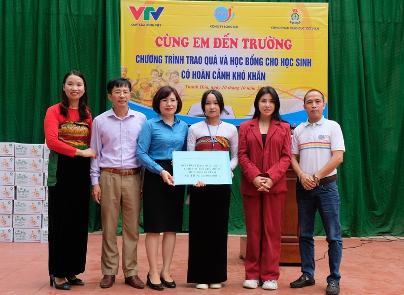 Học sinh Hà Thị Diễm đón nhận học bổng từ chương trình “Viết tiếp ước mơ“. Ảnh CĐ