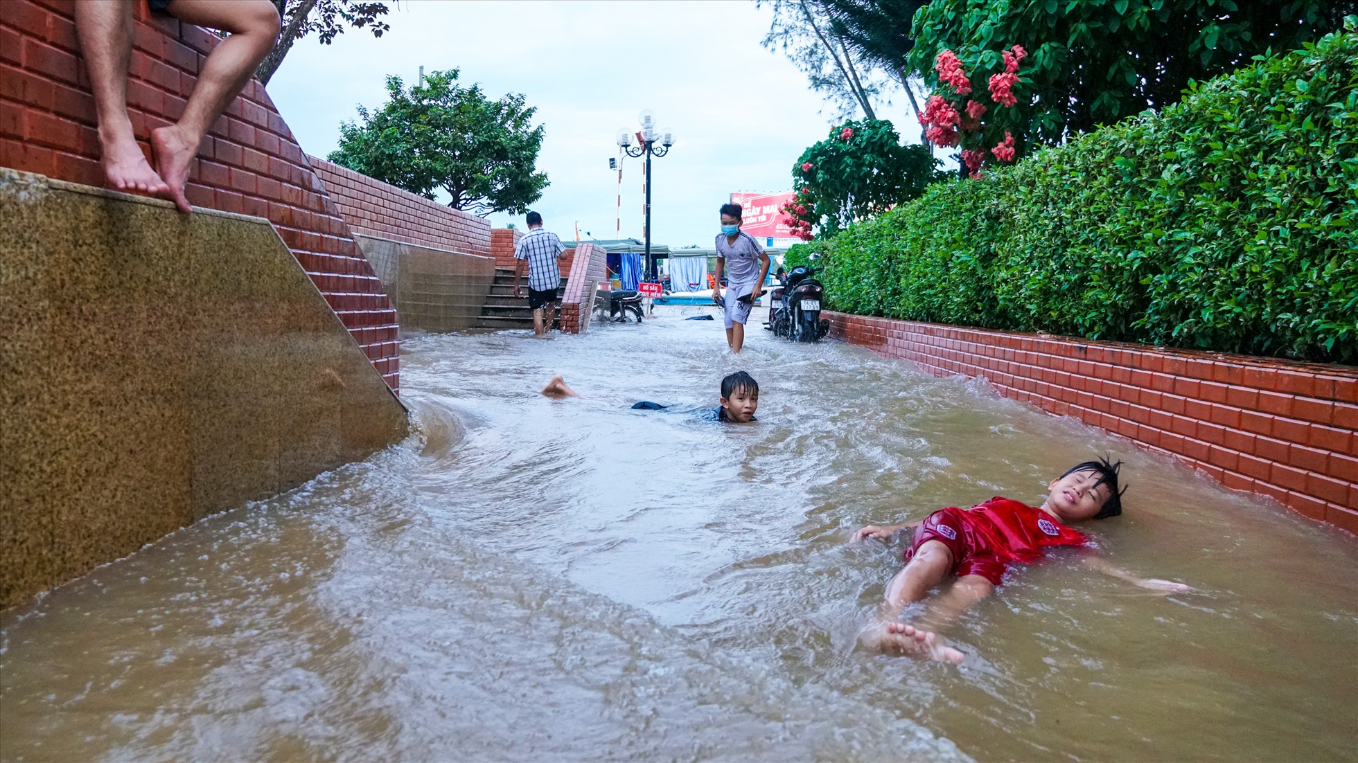 Tại bến Ninh Kiều, người lớn cũng như trẻ nhỏ vui đùa khi mực nước dâng cao.