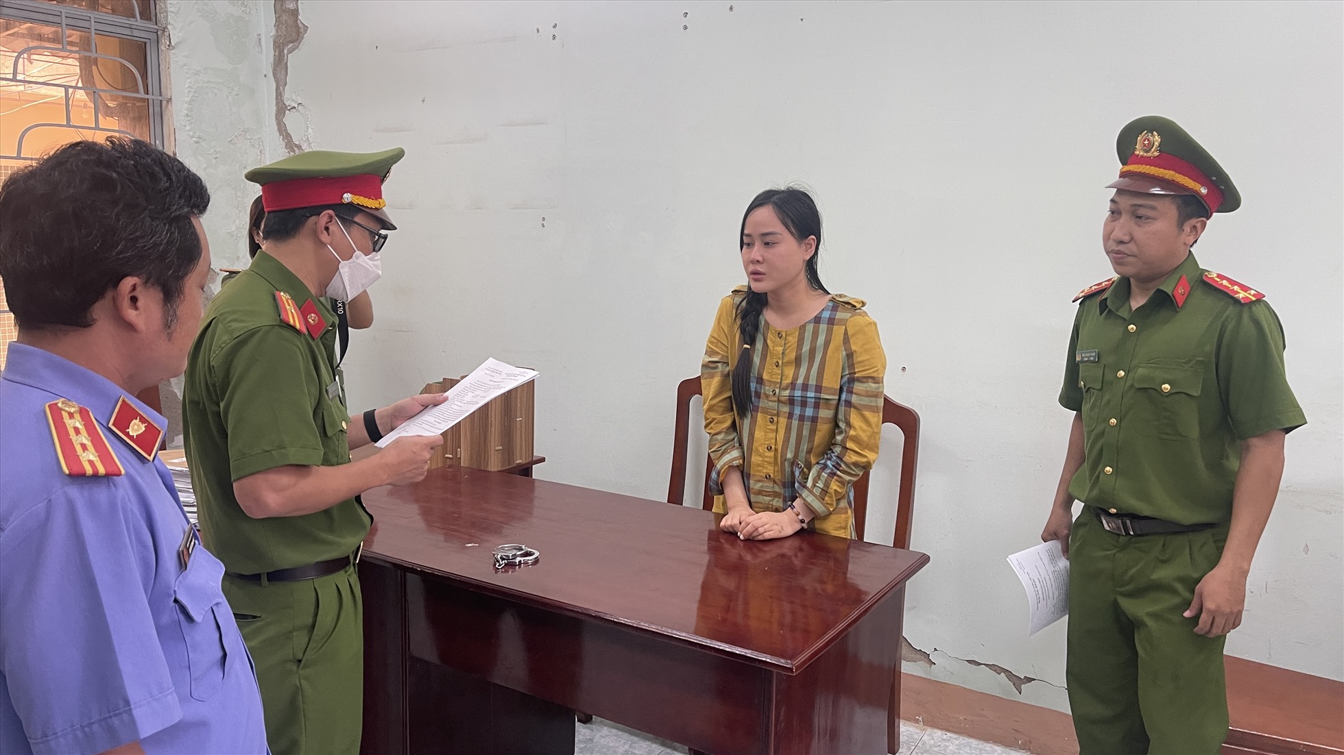 Ninh Thị Vân Anh nghe đọc lệnh tại phòng Cảnh sát hình sự Công an tỉnh Bình Thuận. Ảnh: DT