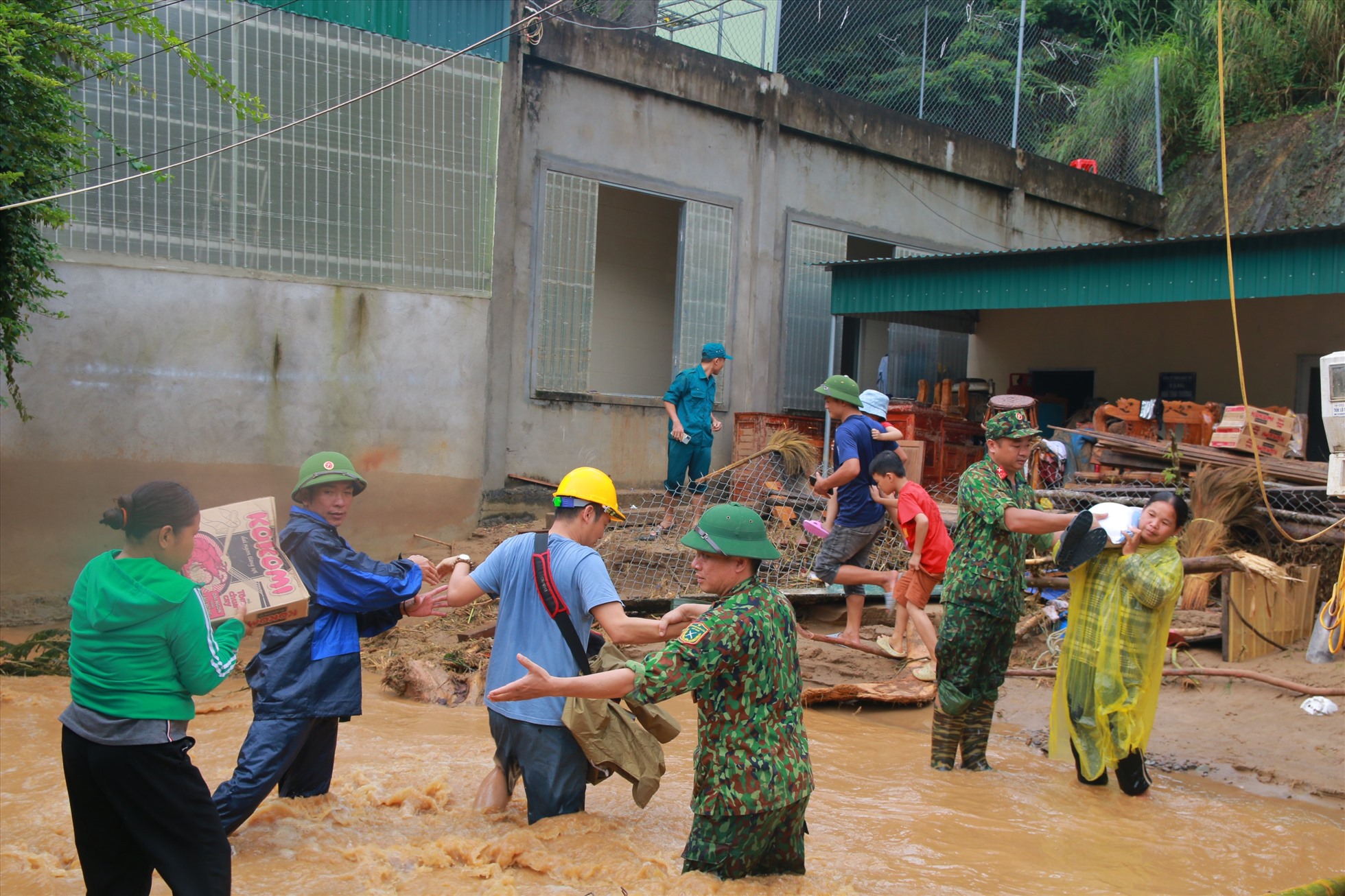 Bộ đội giúp dân Kỳ Sơn vượt qua vùng suối chảy xiết nguy hiểm. Ảnh: QT