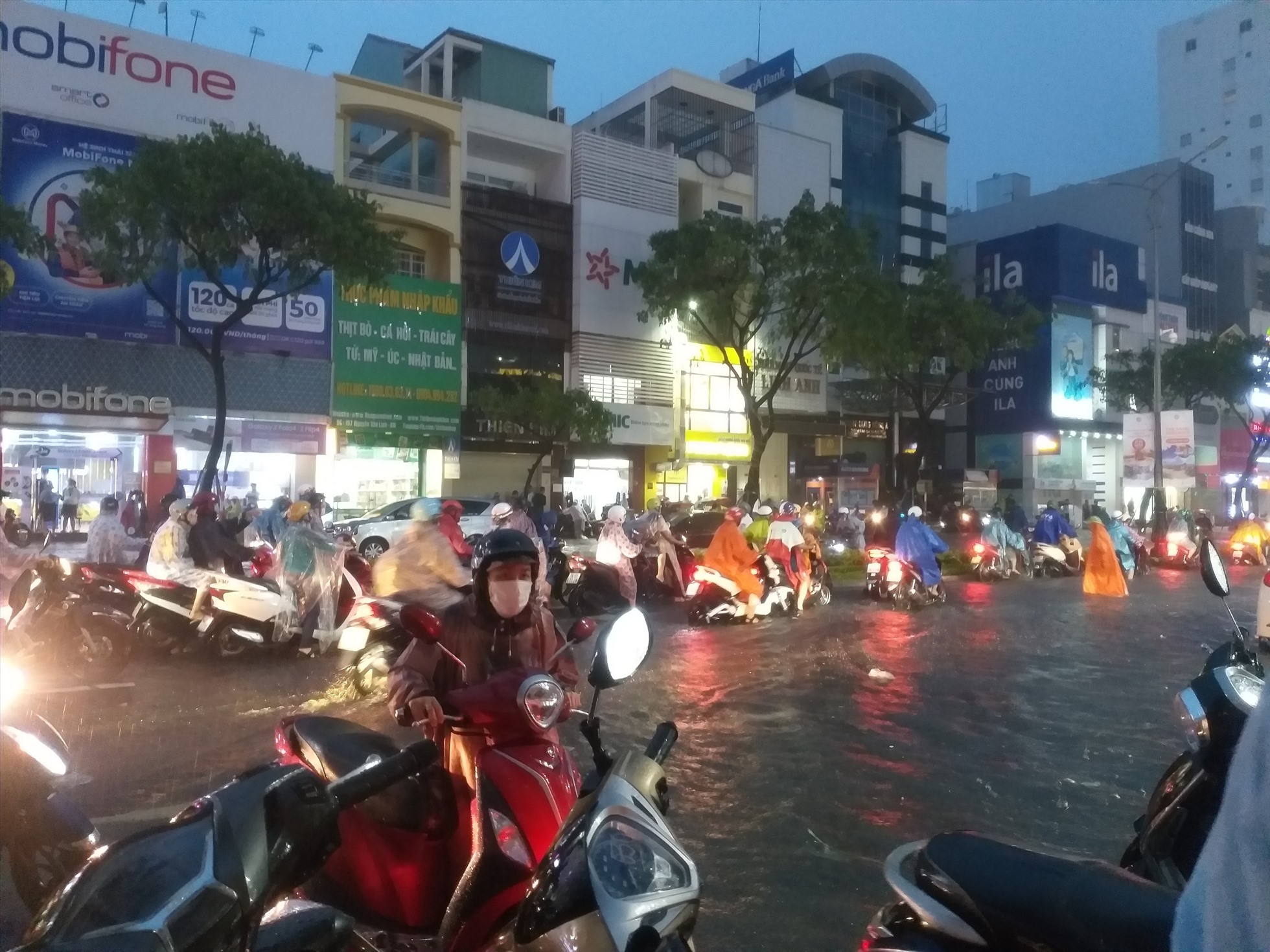 Người dân phải “bơi” trong nước lũ trên đường phố Đà Nẵng chiều tối 14.10. Ảnh: Thùy Trang
