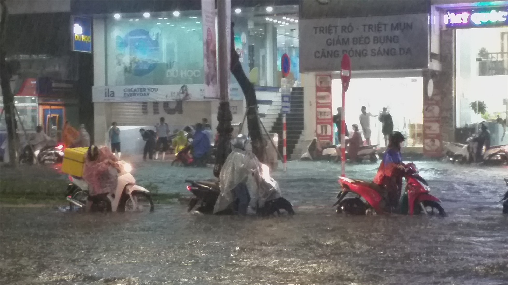 Người dân phải “bơi” trong nước lũ trên đường phố Đà Nẵng chiều tối 14.10. Ảnh: Thùy Trang