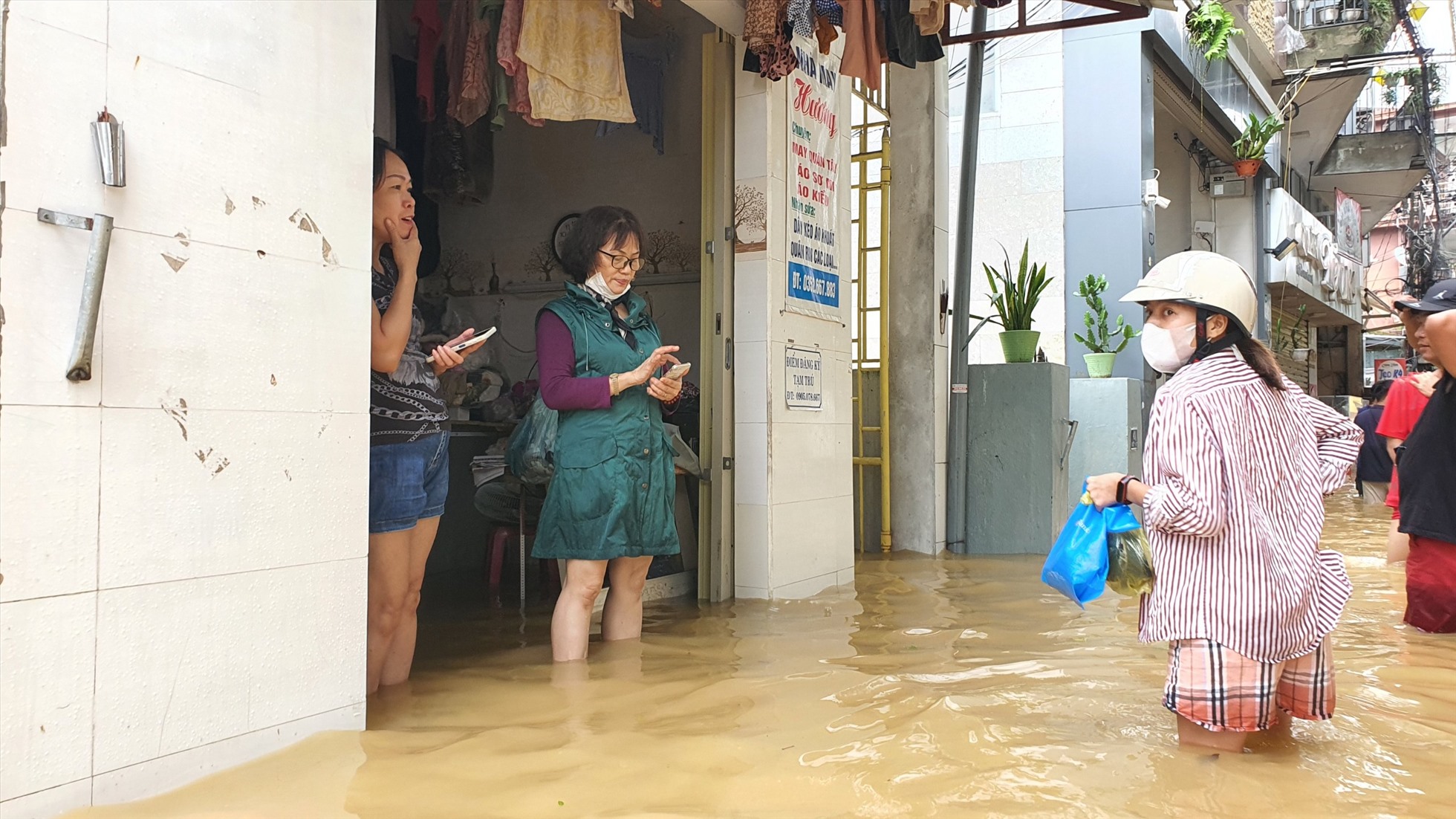 Người dân bì bõm trong nước lũ.