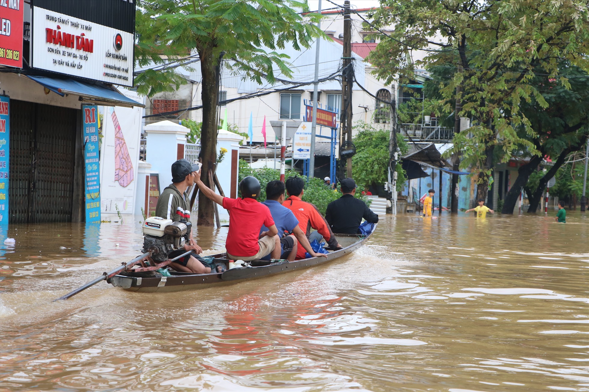 Người dân di chuyển bằng xuồng máy trên đường Nguyễn Huệ.