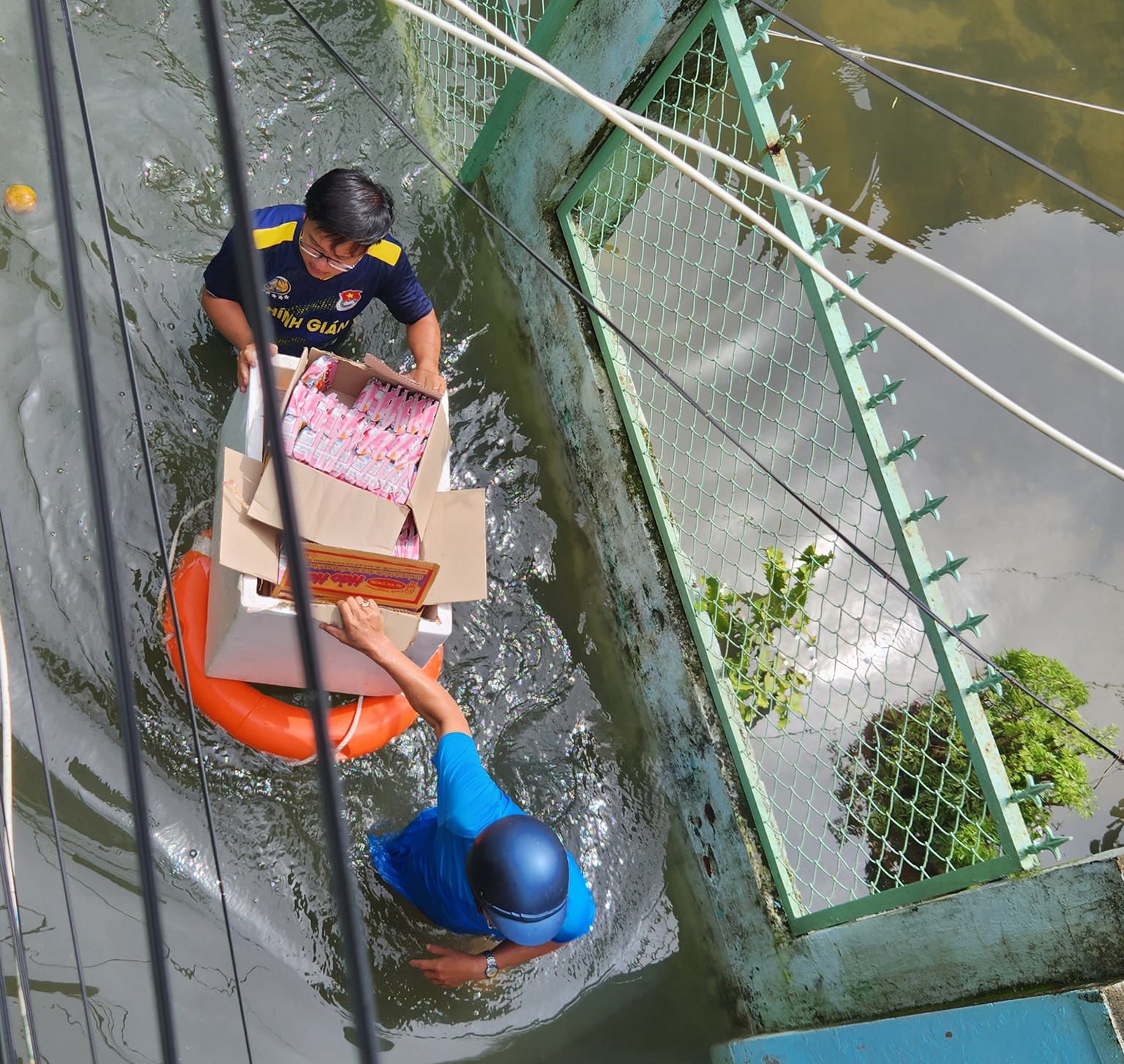 Chính quyền địa phương phát mì gói hỗ trợ dân vùng ngập lụt ở trung tâm thành phố Đà Nẵng ngày 15.10. Ảnh: Nguyên Đức