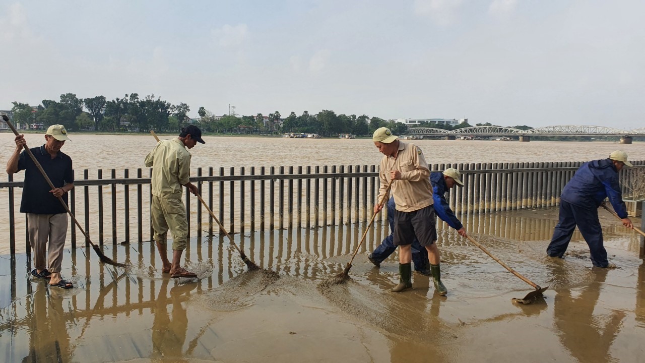 Tranh thủ nước rút, công nhân vệ sinh môi trường cố gắng làm sạch bùn đất cho cầu.