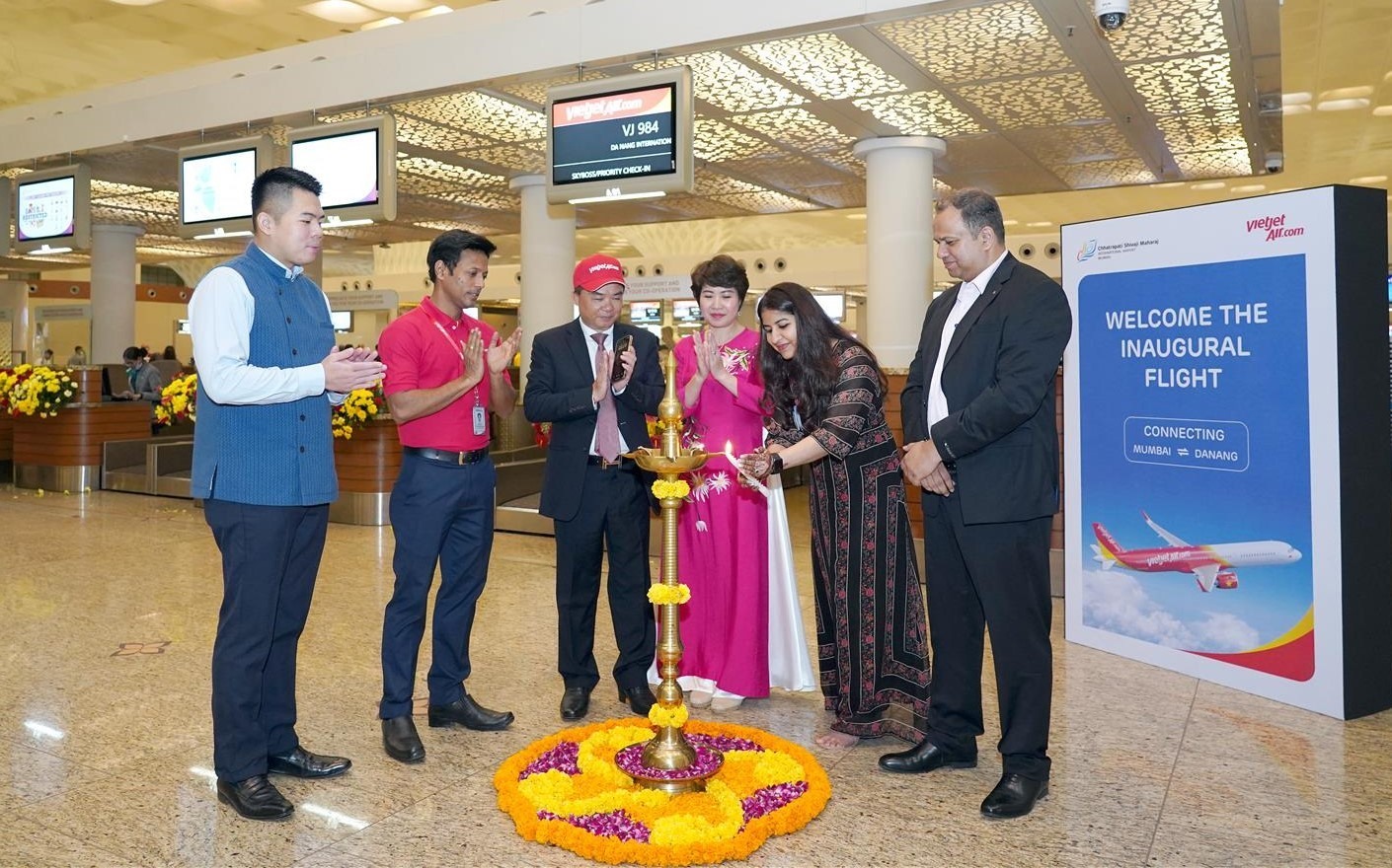Tổng lãnh sự Việt Nam tại Mumbai - ông Hoàng Tùng (thứ 3 từ trái sang) tham dự nghi thức chào mừng và tặng hoa hành khách trên chuyến bay đầu tiên kết nối thành phố Mumbai với thành phố Đà Nẵng.
