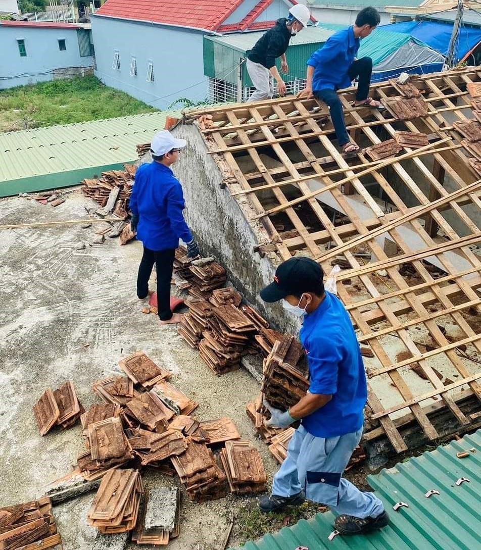 Các đoàn viên thanh niên lợp lại mái nhà cho người dân ở huyện Gio Linh. Ảnh: TĐ.