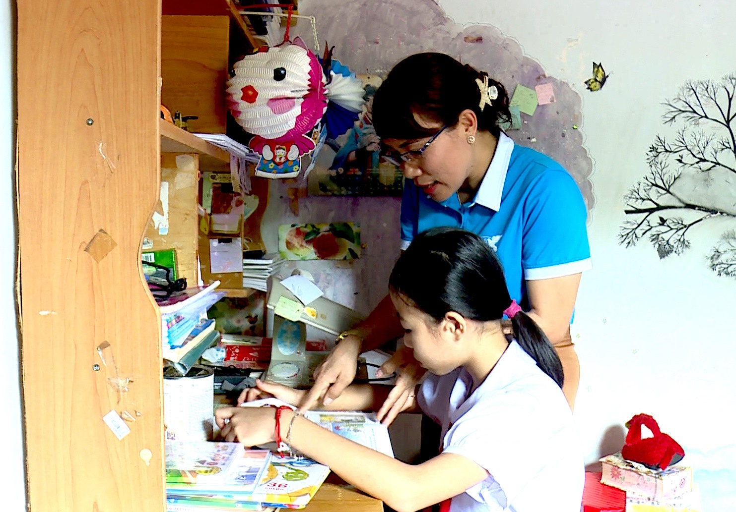 Bà Phạm Thị Tuyến thường xuyên đến động viên, dạy dỗ cho bé Nguyễn Thị Bích Nhi học tập. Ảnh: Trung Dũng