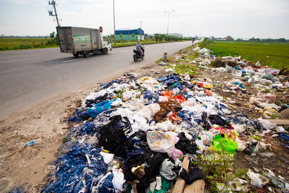 Phế liệu của ngành may mặc cũng “chen chân” phủ kín bãi rác tự phát ven đường.