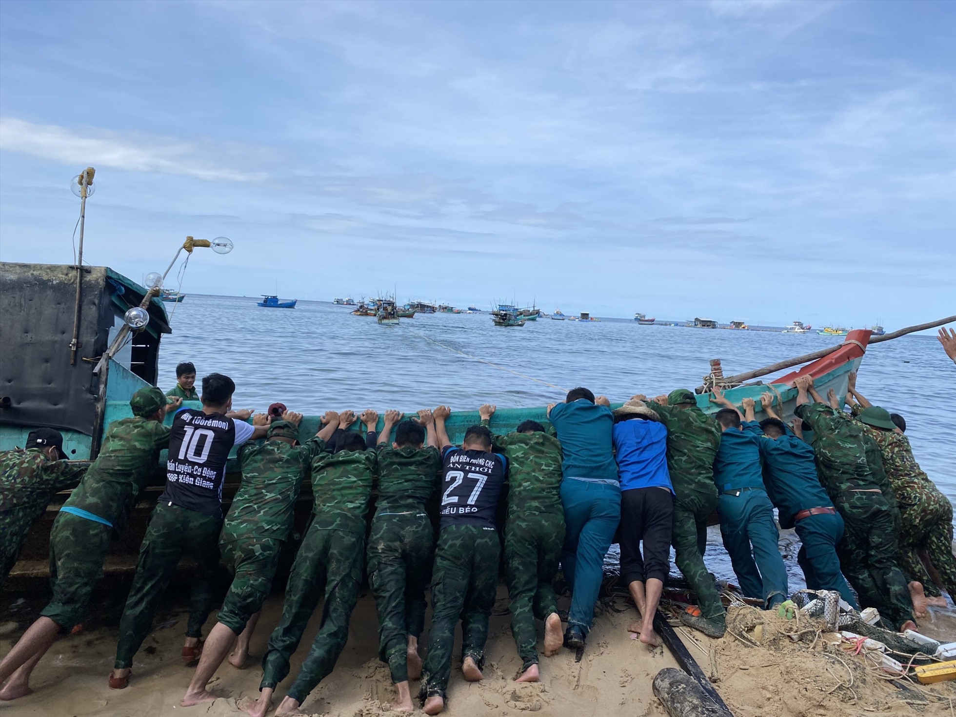 Lực lượng của đơn vị hỗ trợ ngư dân kéo phương tiện ra khỏi bờ, trở về biển. Ảnh: BP