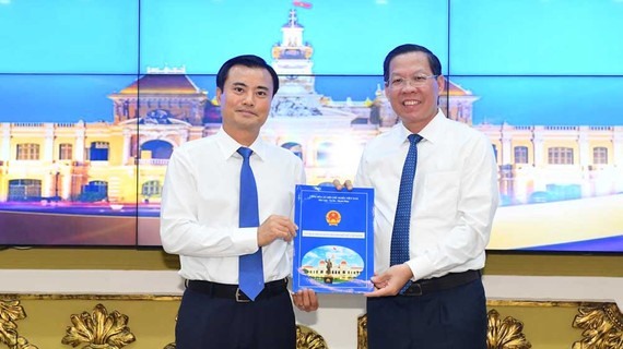 Ông Bùi Xuân Cường (trái) nhận quyết định của Thủ tướng về phê chuẩn chức vụ Phó Chủ tịch UBND TPHCM.  Ảnh: Việt Dũng