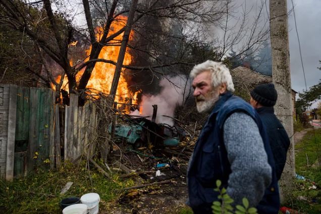 Cư dân ở Bakhmut, thuộc vùng Donbass phía đông Ukraina đứng cạnh một đám cháy sau cuộc pháo kích. Ảnh: AFP