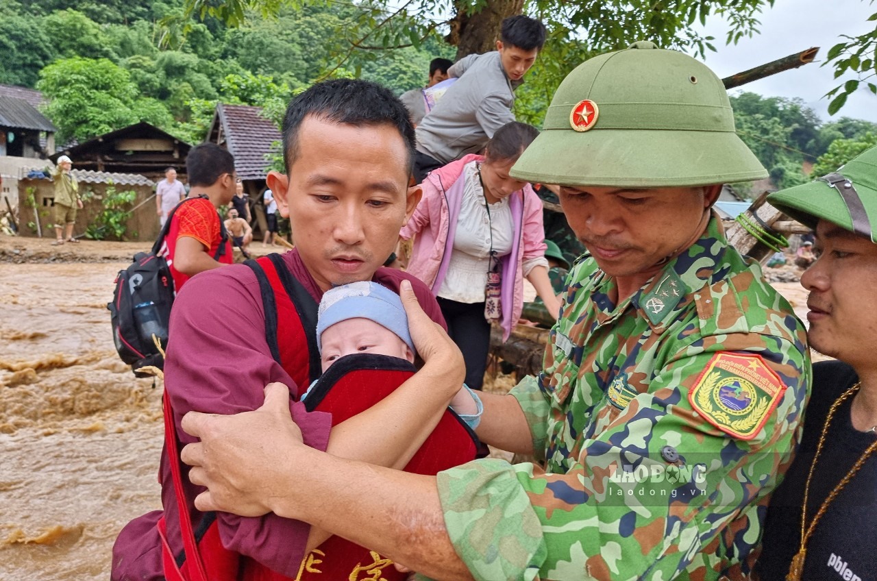 Một cháu bé sơ sinh được hỗ trợ, đưa ra khỏi bản Sơn Hà, xã Tà Cạ - nơi đang bị lũ chia cắt.