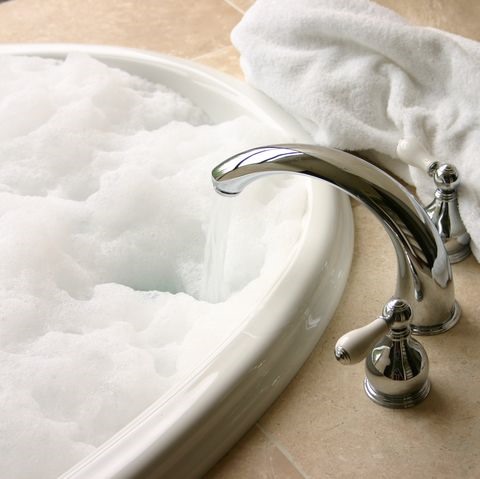 Tắm nước nóng có thể làm dịu các triệu chứng như nghẹt mũi, ho,… Ảnh: Women’s Health