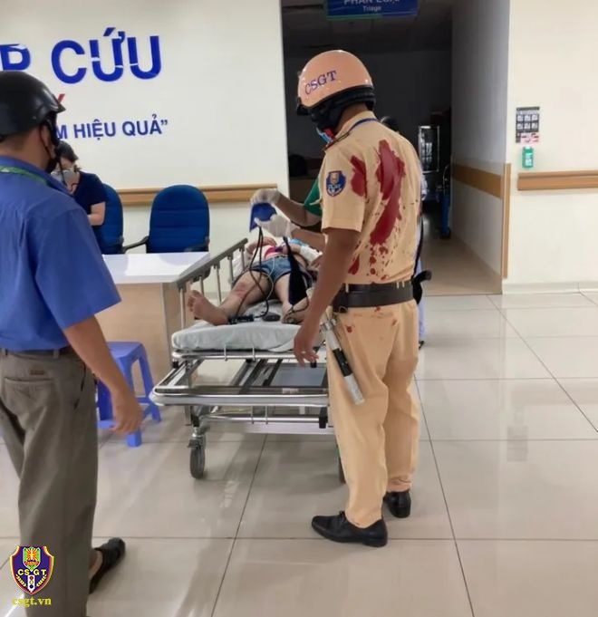 Hình ảnh cán bộ CSGT Rạch Chiếc đưa người bị tai nạn vào bệnh viện cấp cứu, trên áo còn vướng máu. Ảnh: Cục CSGT