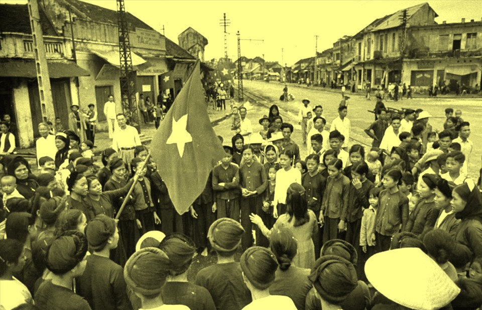Người dân mang theo cờ hoa chào đón đoàn quân tiến vào tiếp quản Thủ đô. Ảnh: Tư liệu