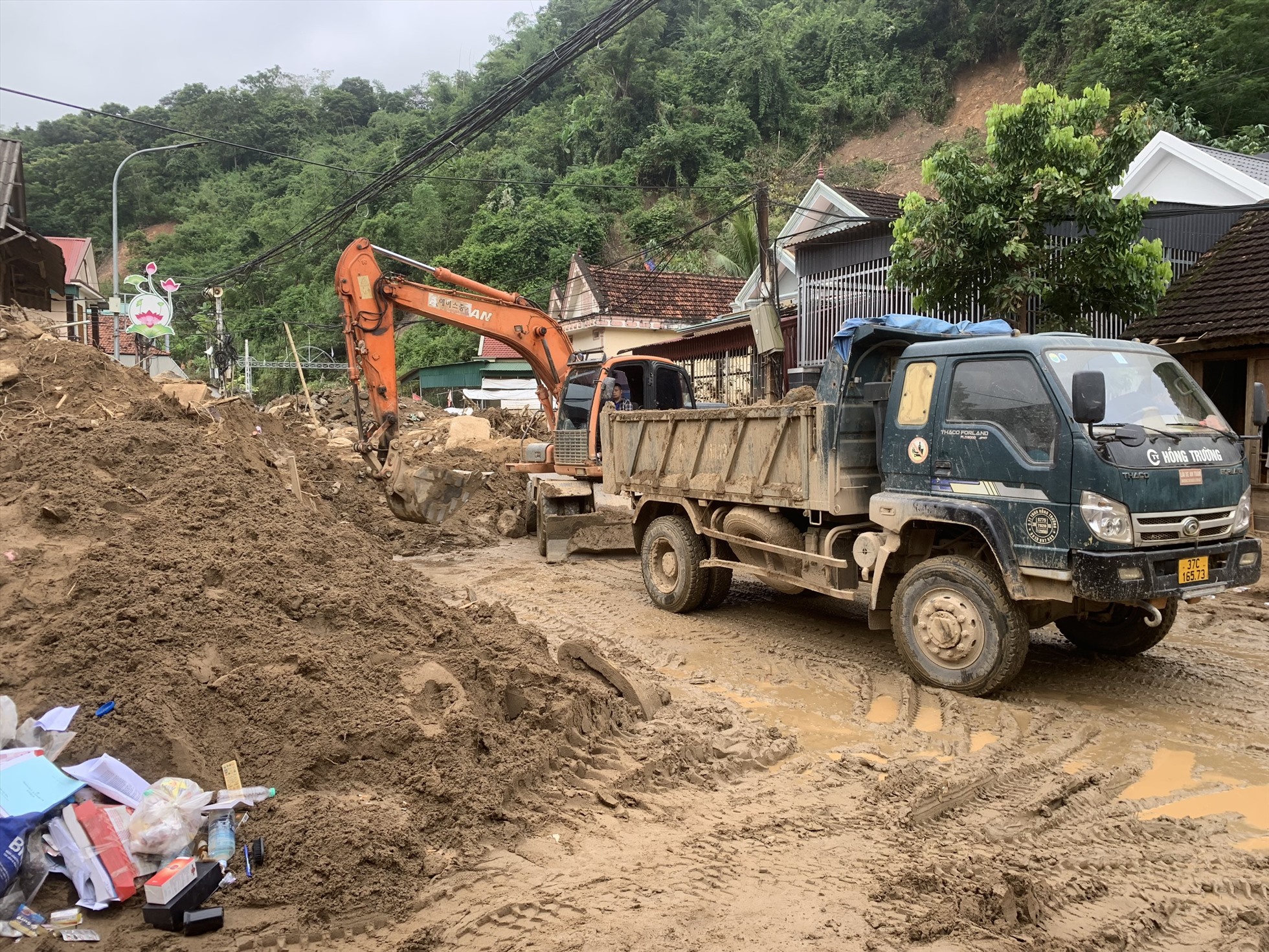Một tuần sau khi cơn lũ quét đi qua, bùn đất vẫn chất cao như núi tại nhiều nơi trên địa bàn thị trấn Mường Xén - trung tâm huyện Kỳ Sơn.