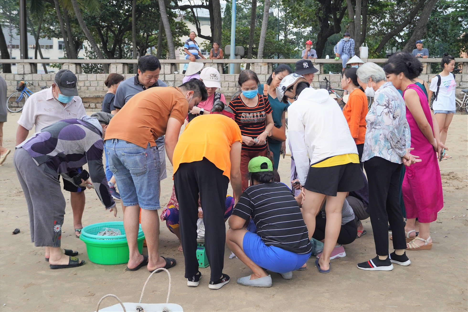 Ngay từ những chiếc ghe đầu tiên đã có đông người dân, du khách xúm lại hỏi mua cá tại bãi biển.