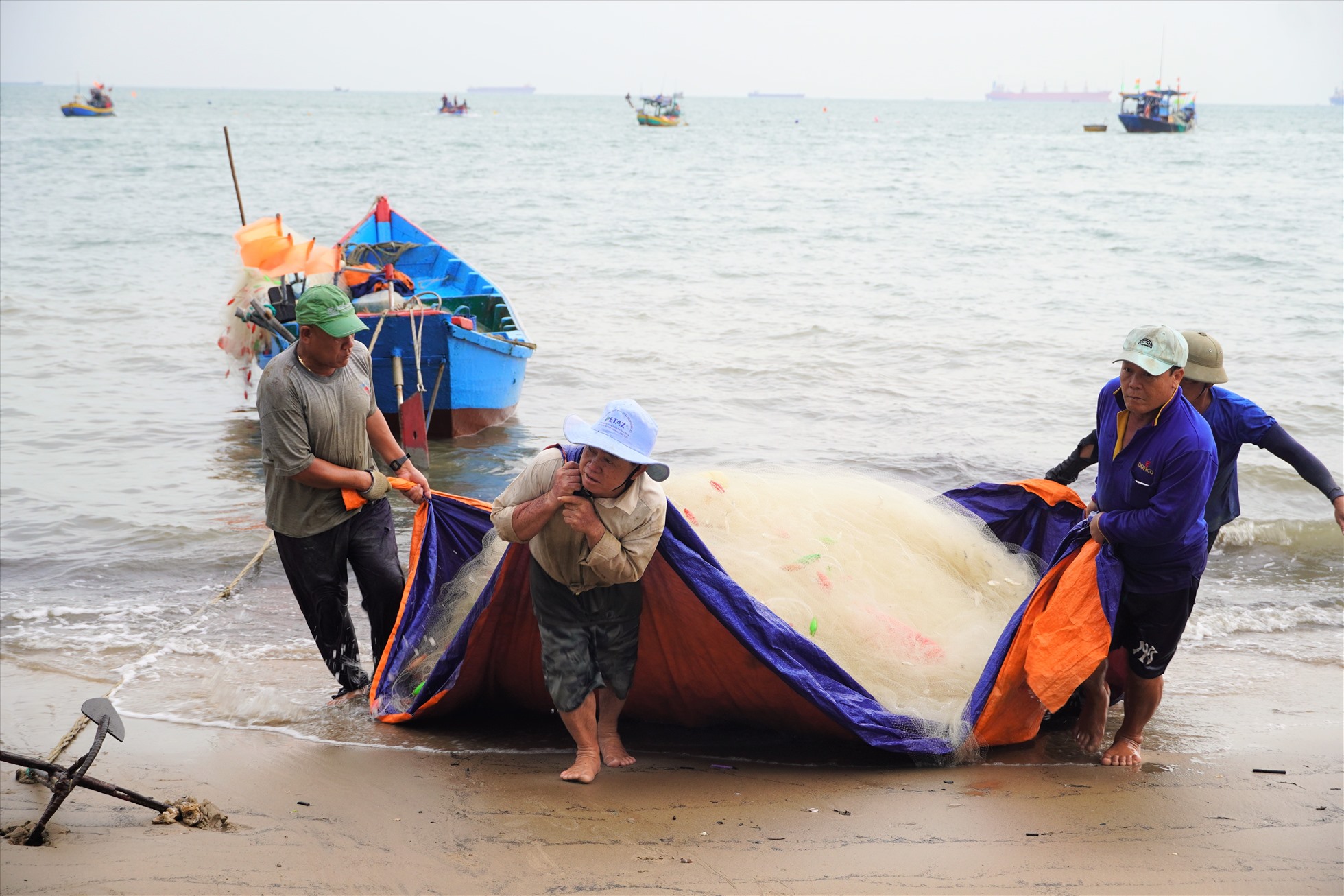 Những mành lưới trĩu cá được ngư dân cùng nhau kéo lên bãi cát.