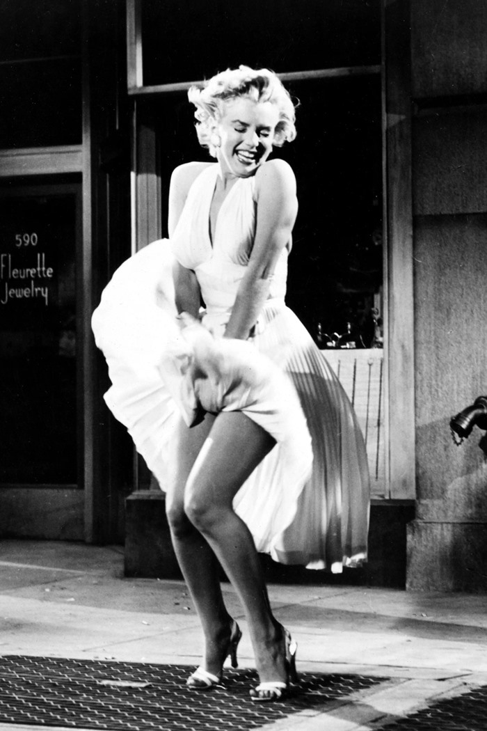 Nhắc đến Marilyn Monroe, bức ảnh cô giữ tà váy trong phim “The Seven Year Itch” được coi là khoảnh khắc kinh điển. Nữ diễn viên đẹp tinh khôi trong chiếc váy trắng tôn lên bờ vai gợi cảm, siết eo và xẻ ngực quyến rũ. Tư thế giữ váy không bị bay giúp Monroe trở thành một biểu tượng của nền điện ảnh giải trí những năm 1920. Nhưng đồng thời, khoảnh khắc kinh điển ấy cũng đẩy cô vào bi kịch hôn nhân đổ vỡ. Ảnh: AP.