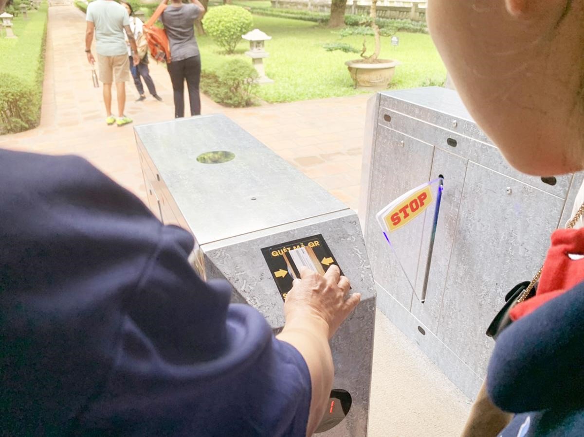 Du khách quét Thẻ Việt - Thẻ du lịch thông minh để qua cổng vào tham quan Khu di tích Văn Miếu - Quốc Tử Giám. Ảnh: TITC