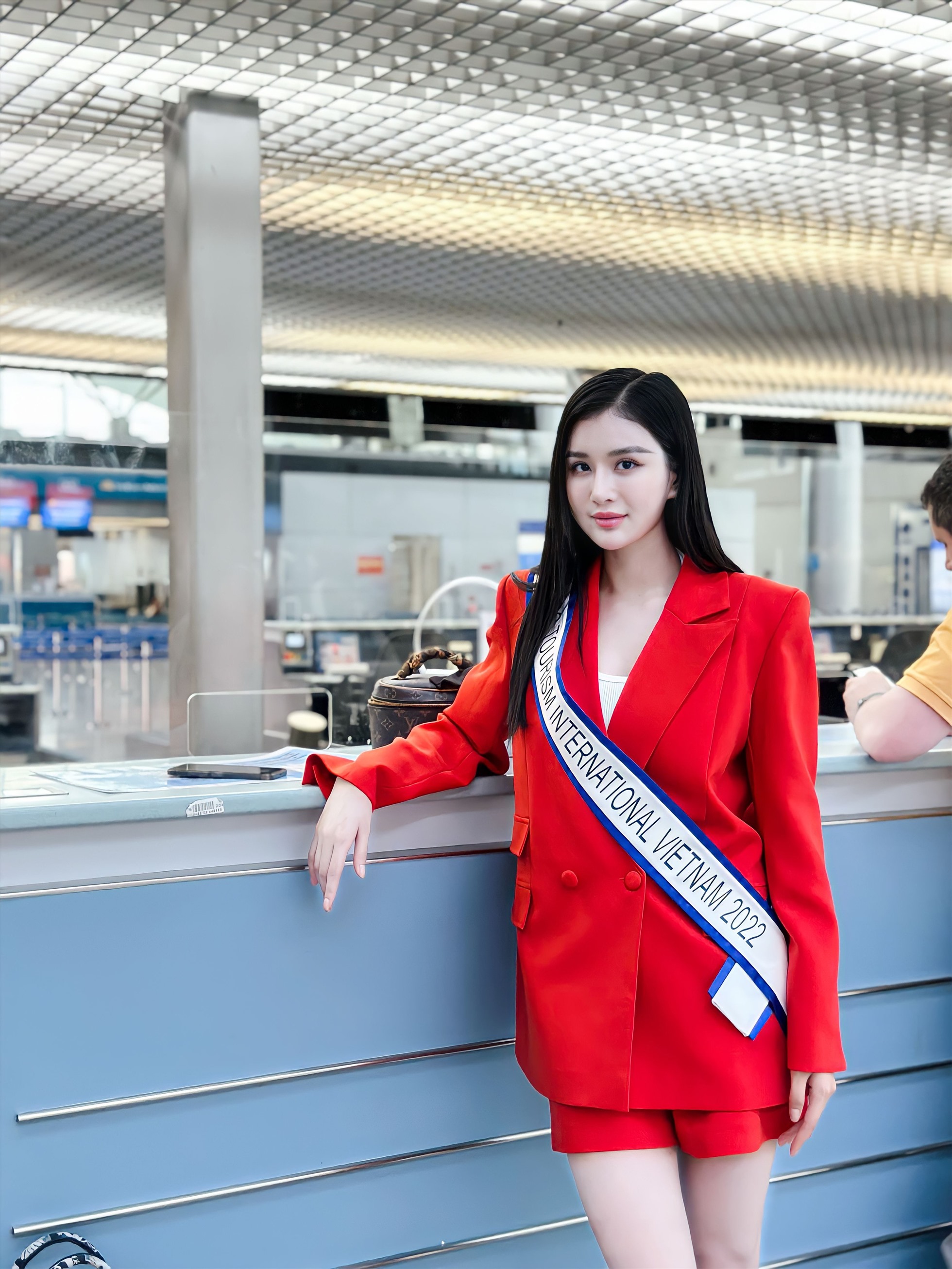 Diện mẫu áo vest nữ dáng dài màu cam, Á hậu Nguyễn Nga nhanh chóng gây thu hút với công chúng và người hâm mộ. Cô mang theo ba vali to chứa rất nhiều trang phục, vật dụng cá nhân và quốc phục được đóng gói riêng.