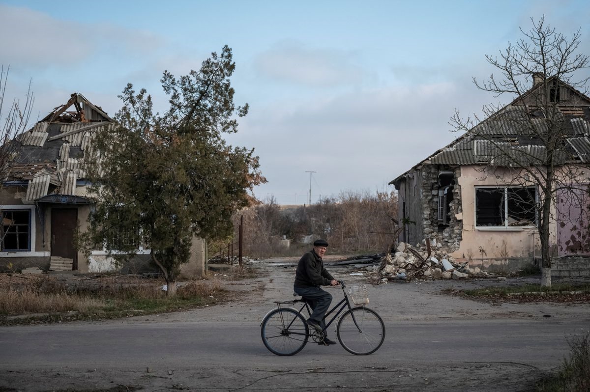 Một người dân địa phương đạp xe gần những ngôi nhà bị phá hủy tại làng Arkhanhelske, Kherson, ngày 8.11.2022. Ảnh: Reuters