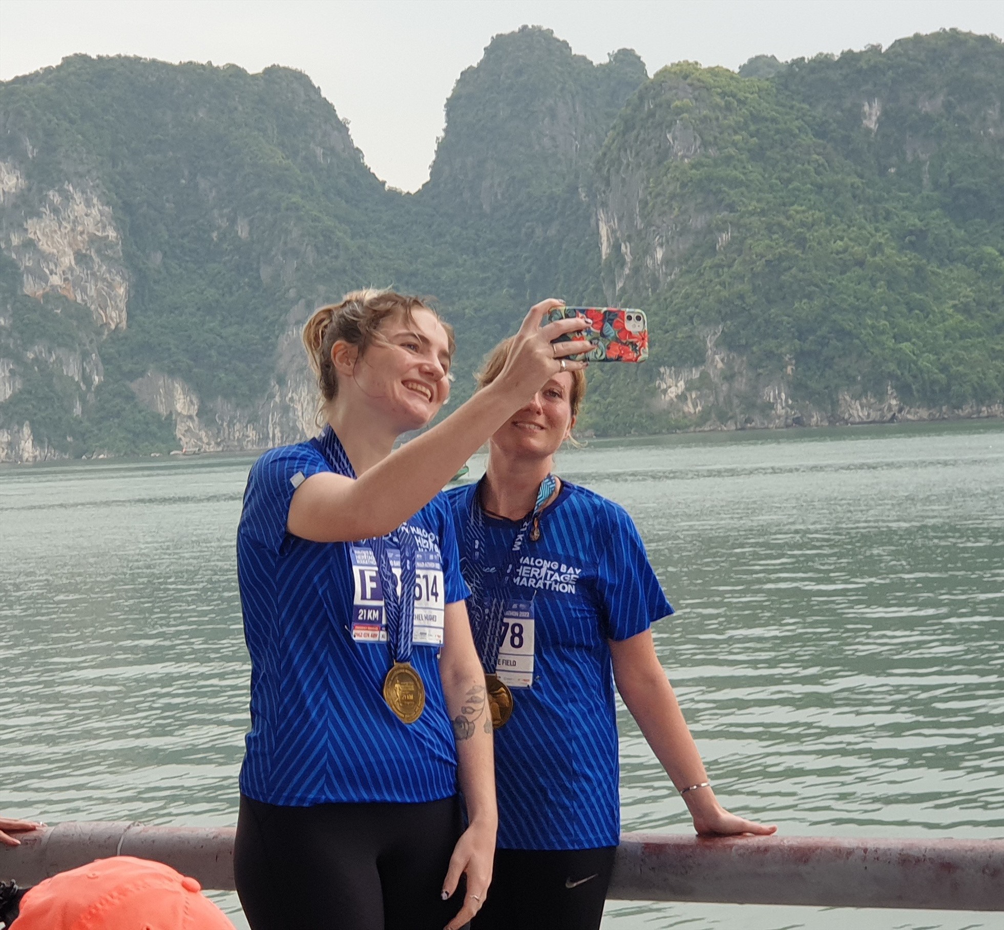 2 VĐV nước ngoài chụp ảnh bên bờ vịnh Hạ Long sau khi hoàn thành cuộc đua. Ảnh: Nguyễn Hùng