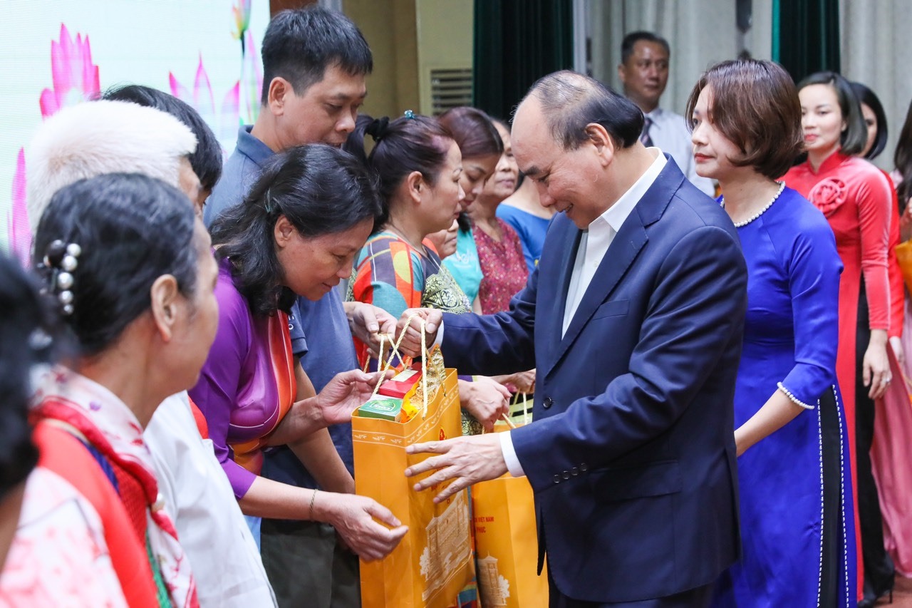 Chủ tịch nước Nguyễn Xuân Phúc tặng quà cho các gia đình có hoàn cảnh khó khăn. Ảnh: Phạm Đông