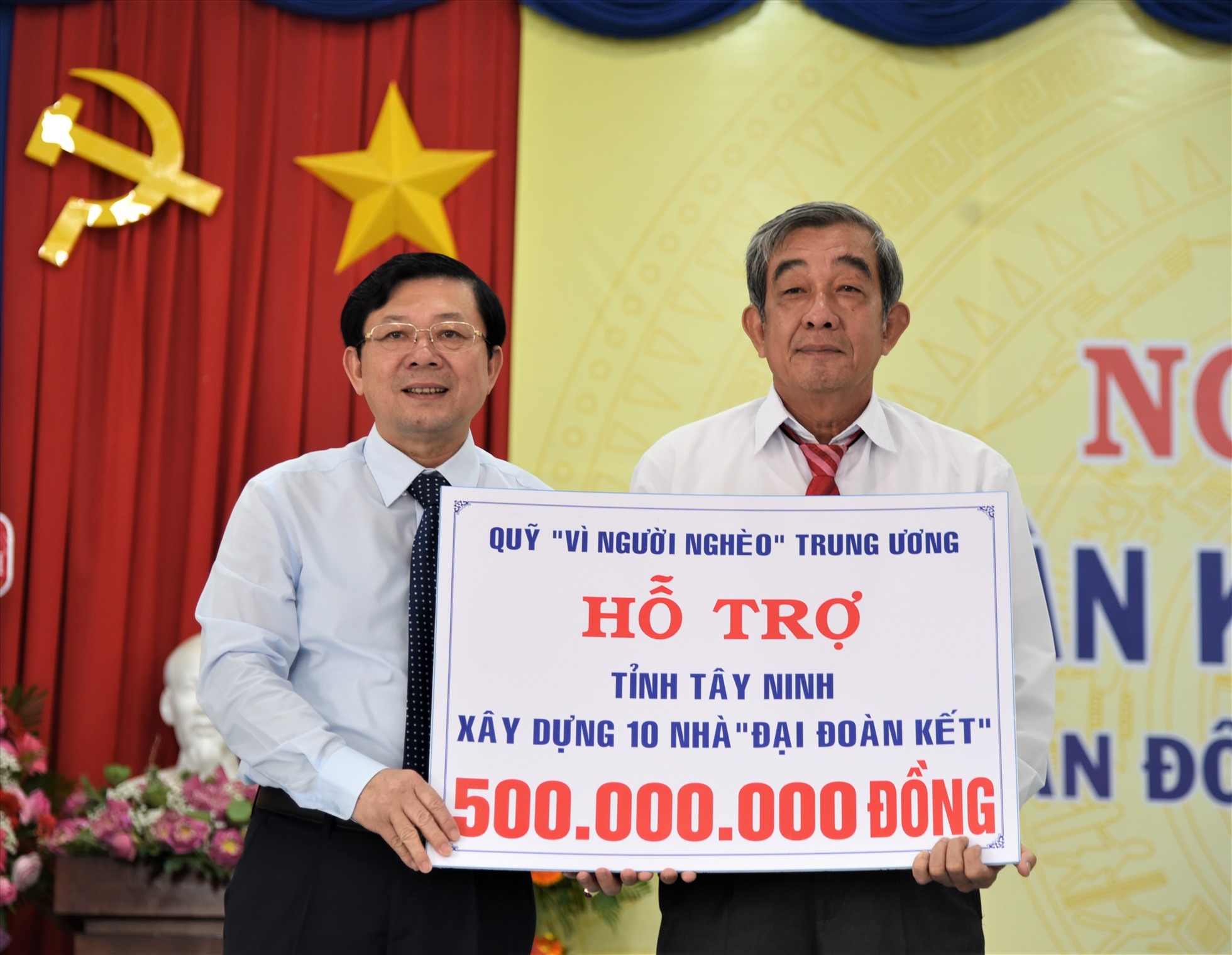 Đại diện Ủy ban Trung ương Mặt trận Tổ Quốc Vệt Nam (bên trái) trao kinh phí hỗ trợ xây dựng 10 nhà Đại đoàn kết cho người dân xã Tân Đông. Ảnh: Nam Dương
