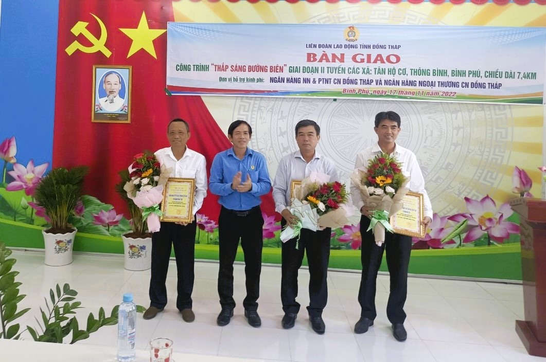 Chủ tịch LĐLĐ tỉnh Trần Hoàng Vũ trao thư cảm ơn và hoa cho đơn vị hỗ trợ, đóng góp thực hiện công trình. Ảnh: Lưu Hùng