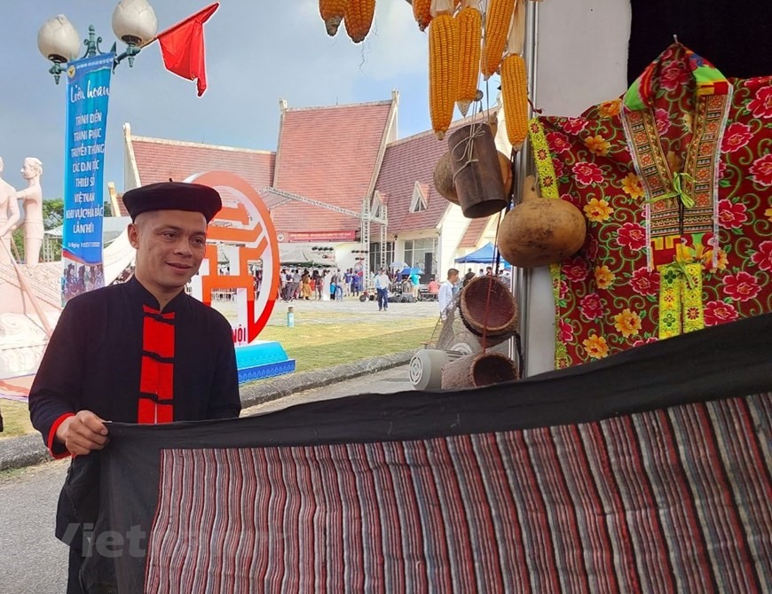 Anh Hà Sơn, dân tộc Dao Tiền ở tỉnh Bắc Cạn khoe tấm vải dệt theo kiểu truyền thống của dân tộc mình. Ảnh: Vietnam+