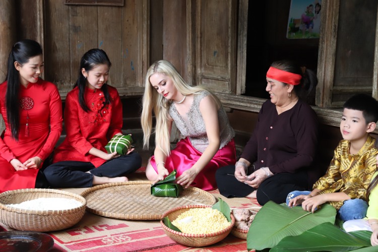 Các thí sinh trải nghiệm gói bánh chưng theo hướng dẫn của nghệ nhân làng cổ Hùng Lô.