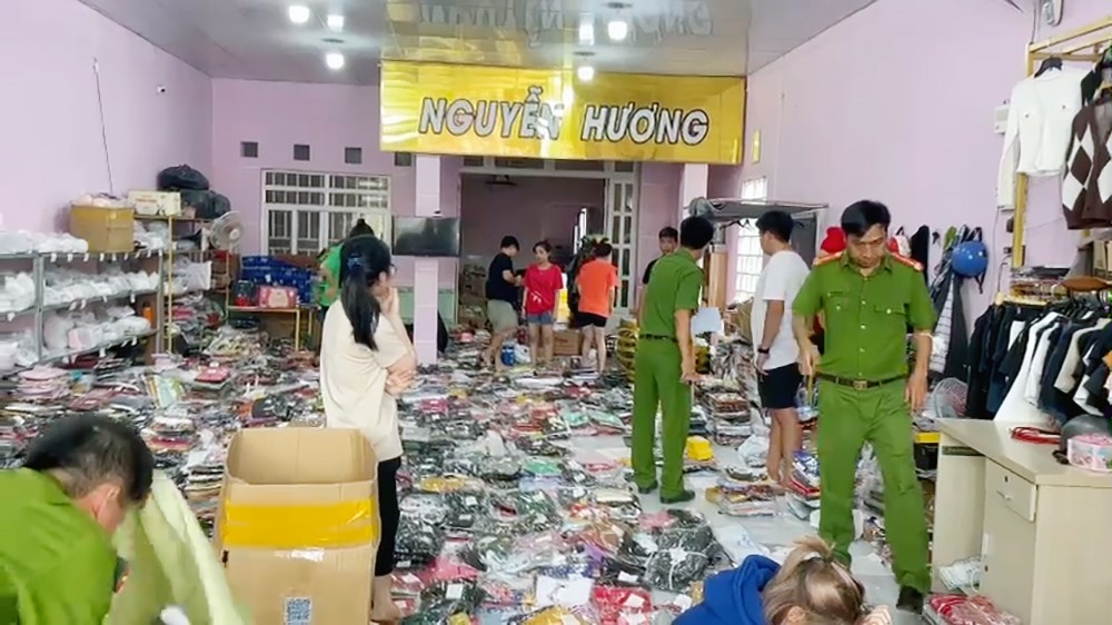 Lực lượng chức năng kiểm tra và phát hiện gần 3.000 sản phẩm không rõ nguồn gốc tại shop thời trang Nguyễn Hương. Ảnh VT