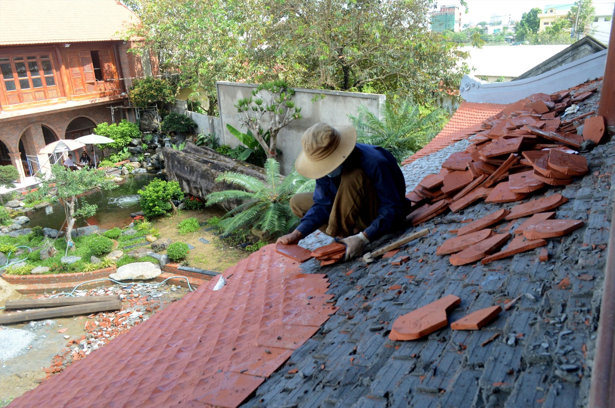 Ông Sơn cho thợ tháo dỡ phần mái công trình xây dựng trái phép trên đất lúa.