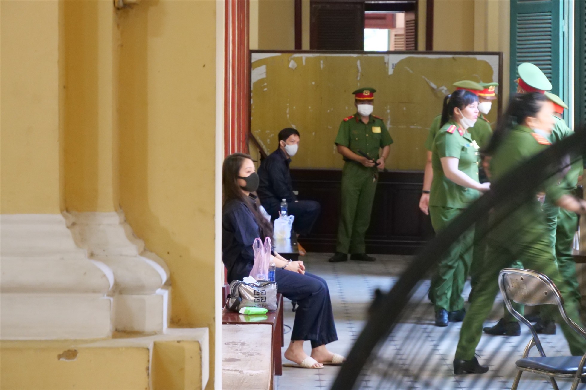 Bị cáo Trang và Thái ngồi bên ngoài phòng xử. Ảnh: Anh Tú