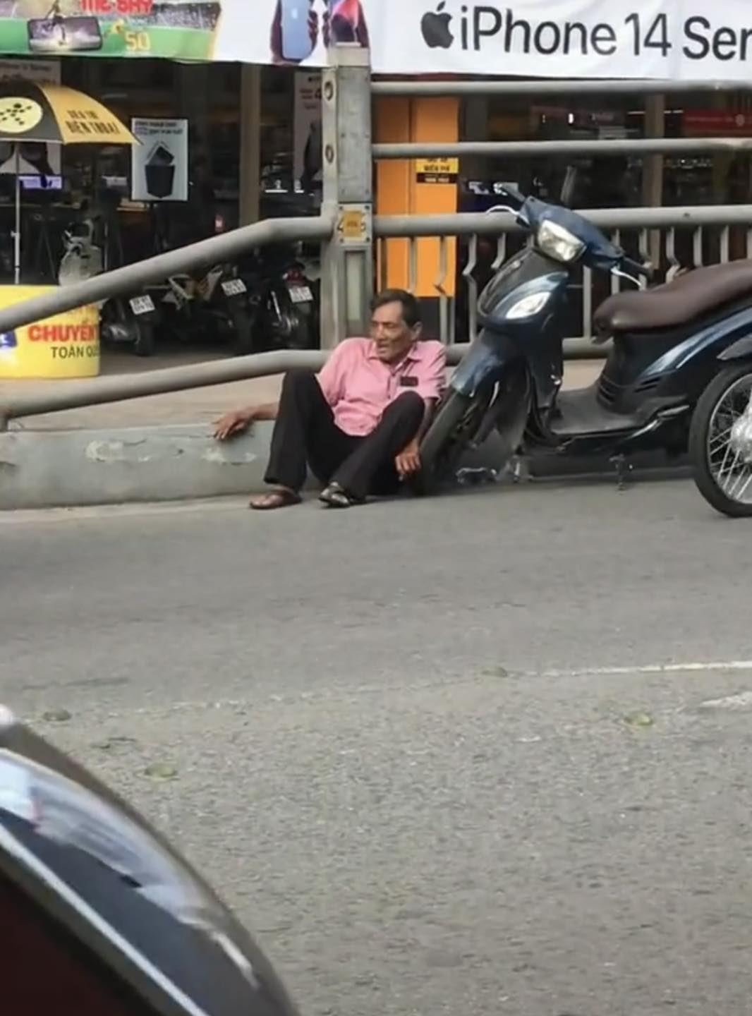 Hình ảnh Thương Tin ngồi bệt trên đường sau khi bị té ngã do sức khỏe kém được người dân quay lại. Ảnh: Cắt từ clip.