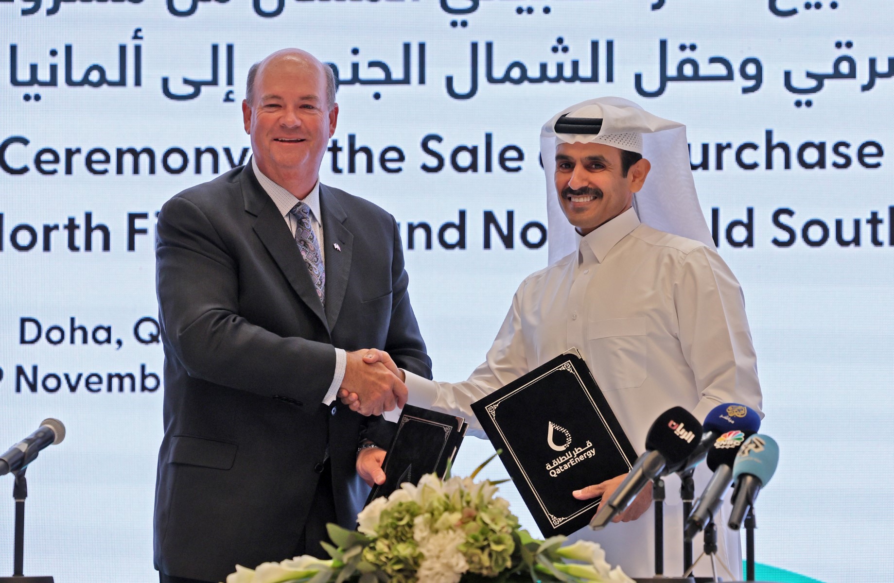 Ông Saad Sherida al-Kaabi (phải), Bộ trưởng Năng lượng Qatar kiêm Giám đốc điều hành Qatar Energy, và ông Ryan Lance, Giám đốc điều hành ConocoPhillips, trao đổi tài liệu trong cuộc họp báo ở thủ đô Doha của Qatar, ngày 29.11.2022. Ảnh: AFP