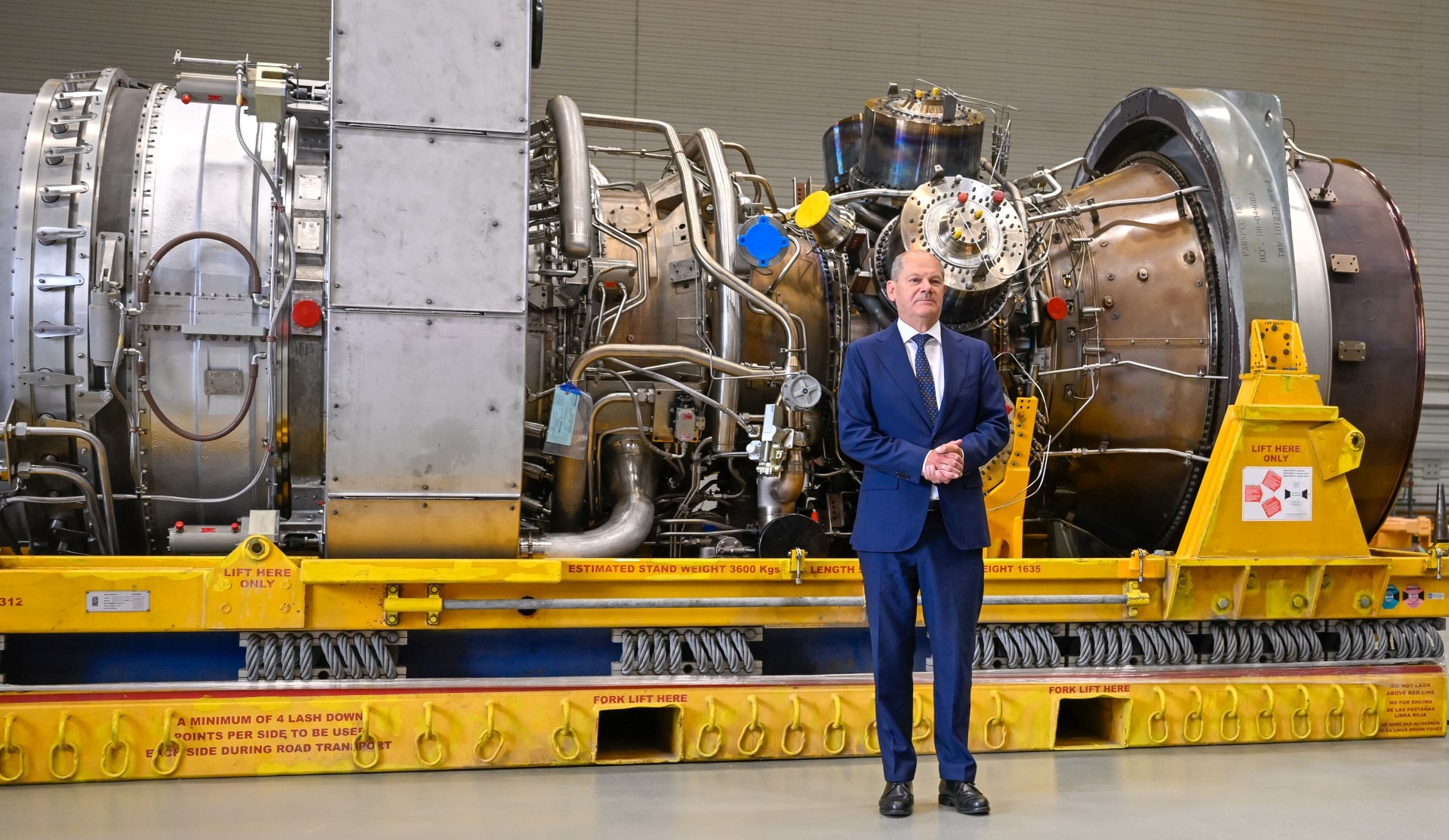 Thủ tướng Đức Olaf Scholz đứng trước một tuabin của đường ống Nord Stream 1 trong chuyến thăm vào ngày 3 tháng 8 năm 2022 tại nhà máy của Siemens Energy ở Muelheim an der Ruhr, miền tây nước Đức, nơi động cơ được cất giữ sau khi bảo dưỡng ở Canada.
