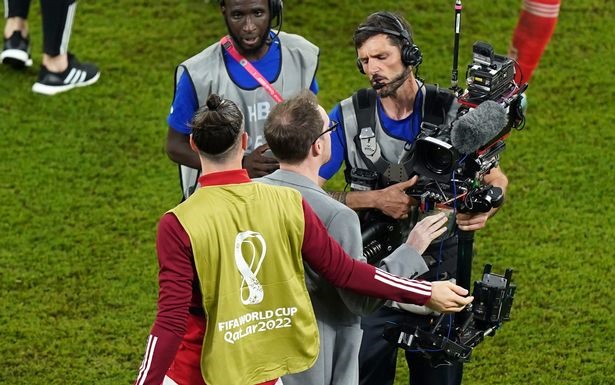 Gareth Bale dùng tay đẩy ống kính máy quay sang một bên để không bị ghi lại cảm xúc sau thất bại. Ảnh: AFP